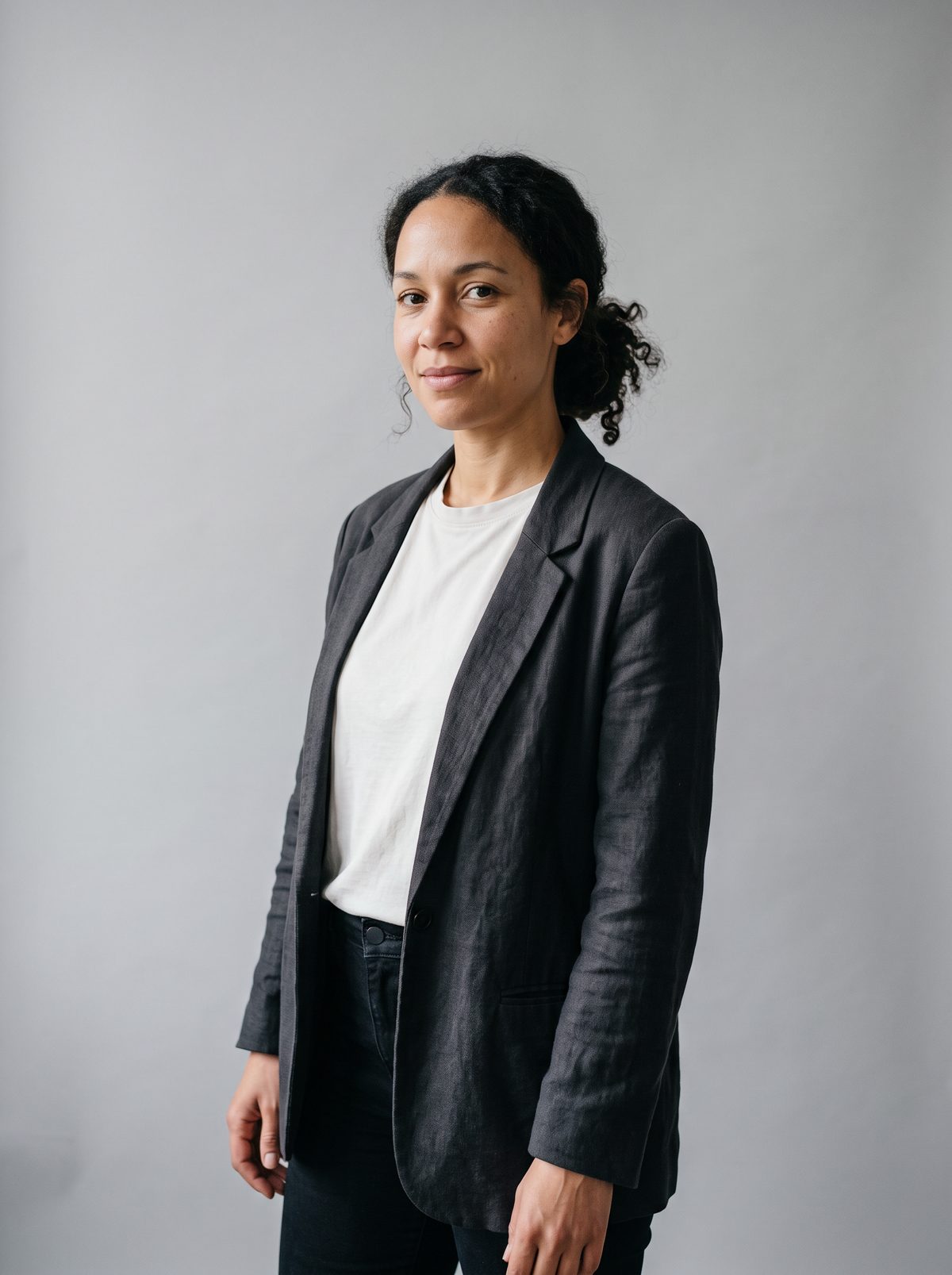 Noor Halden against a grey studio wall, half smiling
